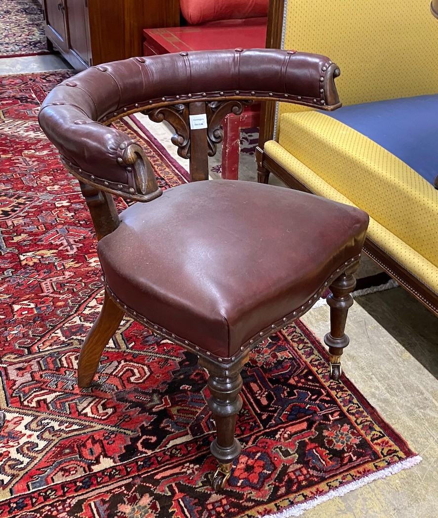 A Victorian oak and burgundy leather desk chair, width 66cm, depth 50cm, height 76cm